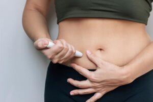 A woman injects her weekly weight loss shot and wonders how long semaglutide stays in your system.