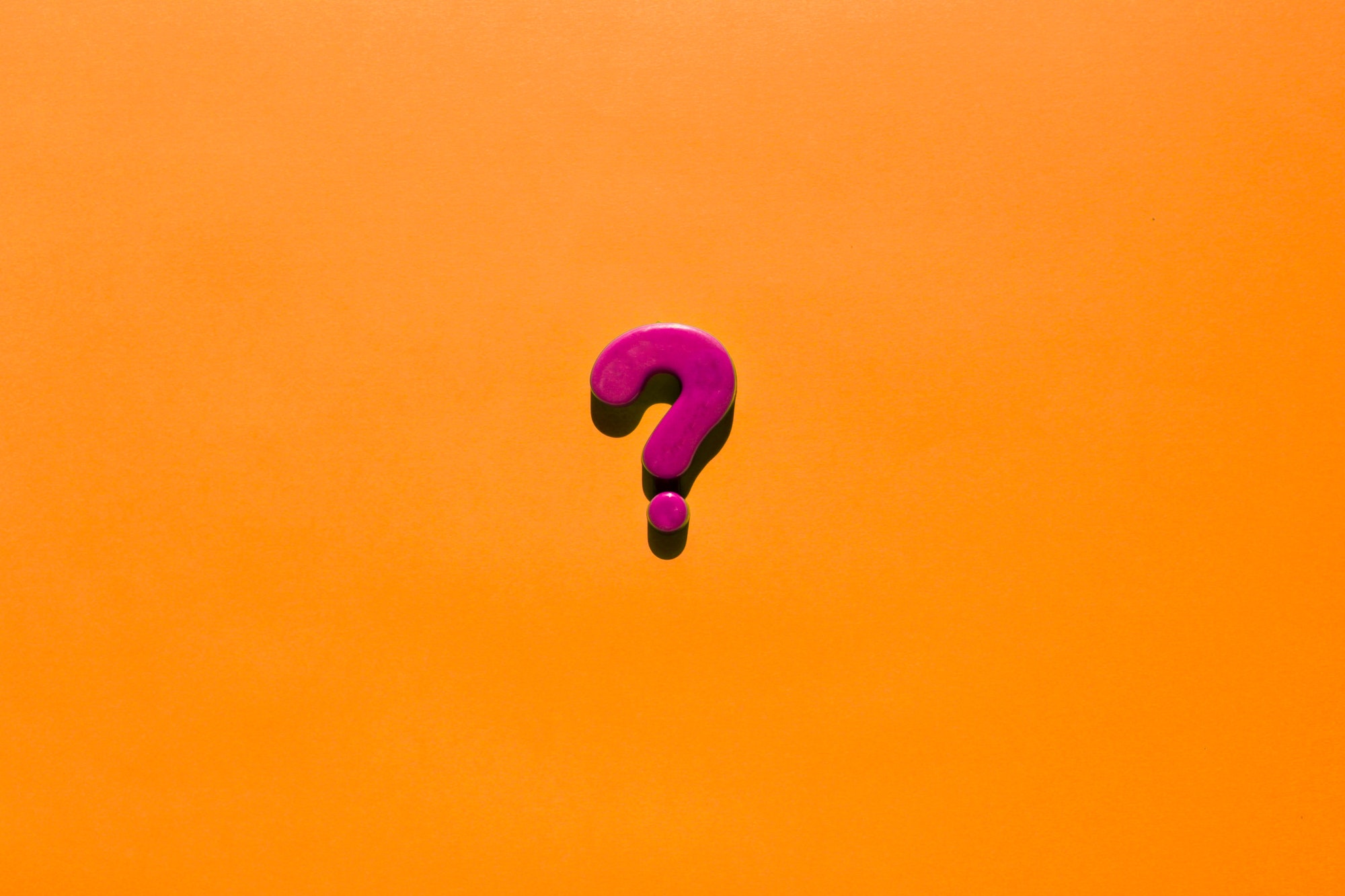 Pink question mark on a orange background